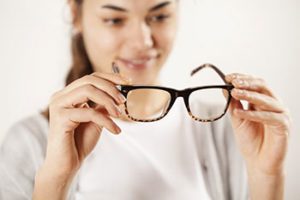 woman holding a pair of eyeglasses